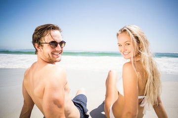 Fototapeta premium Happy couple sitting on the beach
