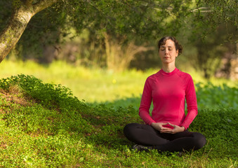 Young caucasian woman meditating outdoors