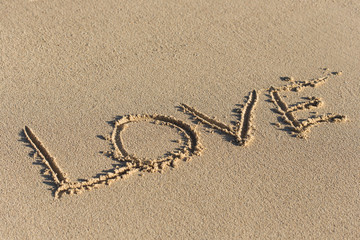Inscription Love on sandy beach