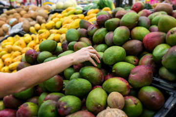 Woman taking fresh mango at the market