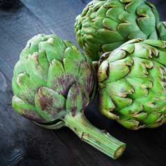Obraz premium Fresh green artichokes on wooden table
