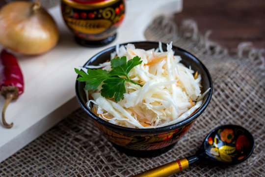 Sauerkraut with carrot in wooden bowl
