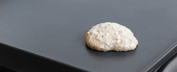 Oat pancake cooking on electric barbecue