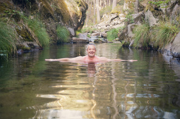 Adult man enjoying a relaxing bath in the river
