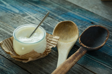 Jar with fresh yogurt on a rustic table