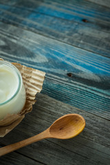 Jar with fresh yogurt on a rustic table