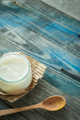 Jar with fresh yogurt on a rustic table