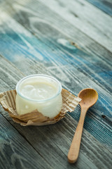 Jar with fresh yogurt on a rustic table