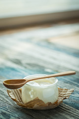 Jar with fresh yogurt on a rustic table