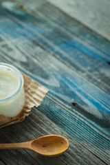 Jar with fresh yogurt on a rustic table