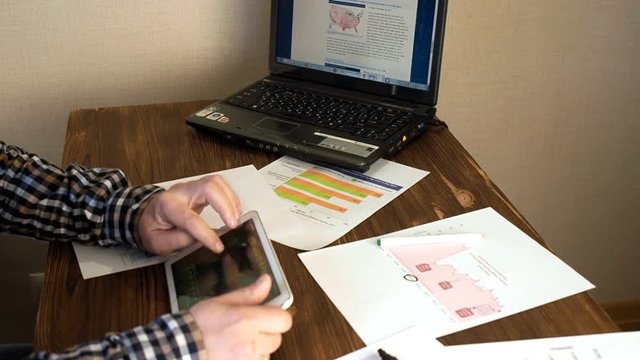 Home office worker using laptop computer and tablet PC close up