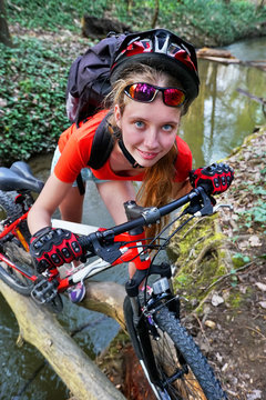 Bikes cycling girl. Girl rides on log. Girl cycling fording throught water . Cycling trip is good for health. Cyclist watch your up at camera. Top view.