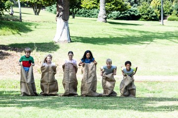 Children having a sack race in park