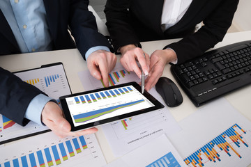 Two Businesspeople Analyzing Graph On Digital Tablet