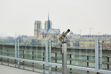 Fototapeta premium Touristic telescope with view on the Notre Dame in Paris, France