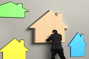 Business person putting wooden house in suitable hole