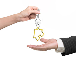 Woman hand giving key with house keyring to man hand