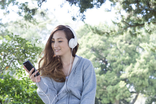 Women are listening to music in a natural rich park