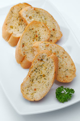 close up view of some sliced garlic bread  on whit back