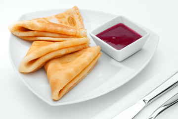 close up view of nice yummy crepes with jam on white  table