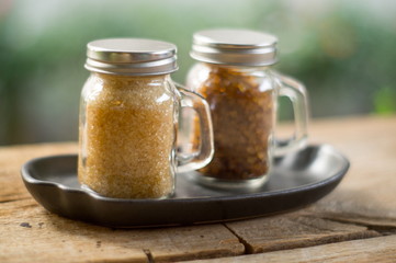 Brown sugar in glass bottle on wooden table