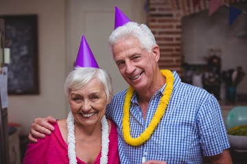Smiling senior couple wearing party hat