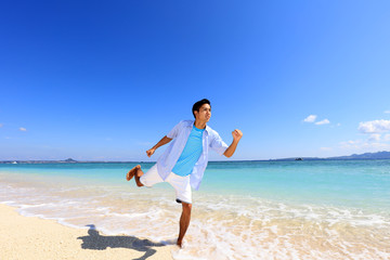 Fototapeta na wymiar 南国の美しいビーチを走る笑顔の男性