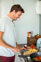 Fototapeta na wymiar Young man cutting vegetables at home