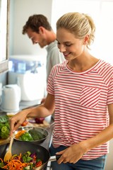 Happy young coupe preparing food in kitchen