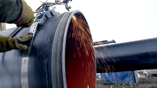 Industrial worker cutting steel duct pipe by using metal torch