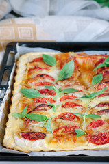 pie of puff pastry with tomato, mozzarella and pesto sauce