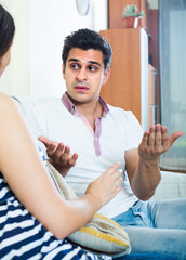 Young couple during indoor quarrel .