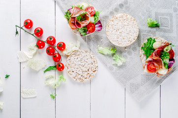 Sandwich with rice cake, lettuce, mozzarella, tomatoes and prosciutto