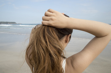 Women are bundled the long hair while looking at the sea