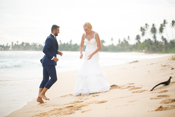 Fototapeta na wymiar bride and groom playing on the beach