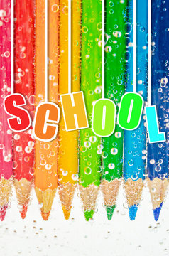 School. Close up colorful wooden pencils in sada water.
