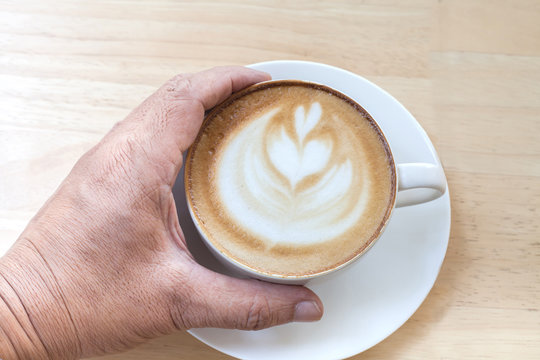 hand holding coffee cup.