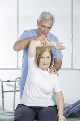 Fototapeta premium Physical therapist helps an elder patient