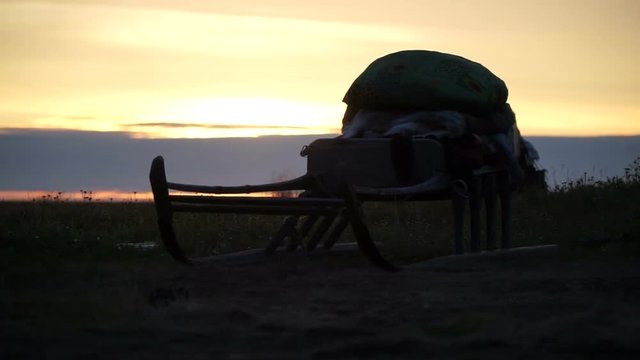 Sunset in the tundra. Sleds in the sunshine.
