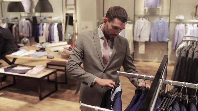 young man choosing clothes in clothing store