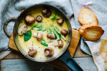 Melting mozzarella in pan with mushrooms, basil and garlic croutons