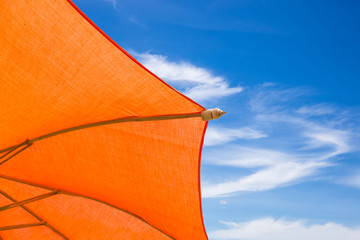 Fototapeta na wymiar Orange parasol or umbrella on blue sky background.