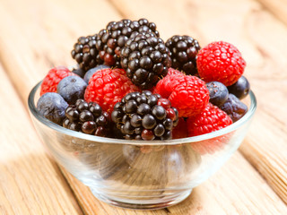 blueberries blackberries and raspberries in glass bowl