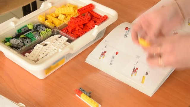 Teacher making a robot from educational kit
