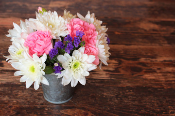 Blumenstrauß, Astern, Nelken auf Holztisch mit Textfreiraum