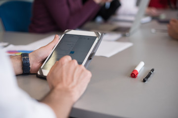 close up of  businessman hands  using tablet on meeting