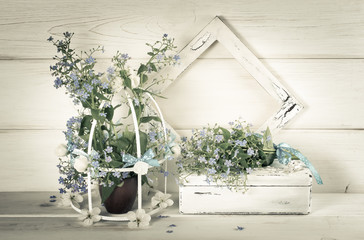 Forget-me-not flowers with birdcage and photo frame and casket