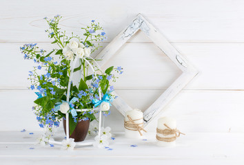 Forget-me-not flowers with birdcage and photo frame and candles