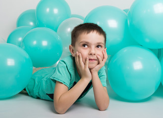 young man lying on the floor, around him are balloons