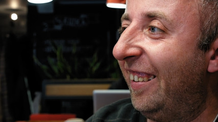 Man's emotional close portrait with big expressive eyes significant nose and small stubble beard. Dialog friendly conversation scene. 